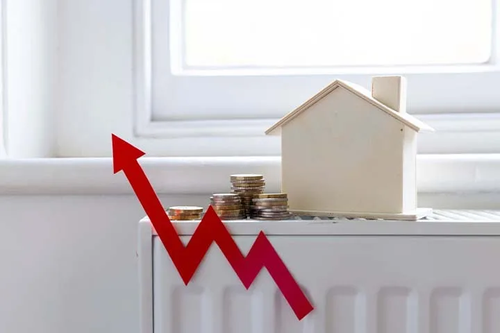 Digital thermostat and radiator showing central heating cost per hour in a UK home